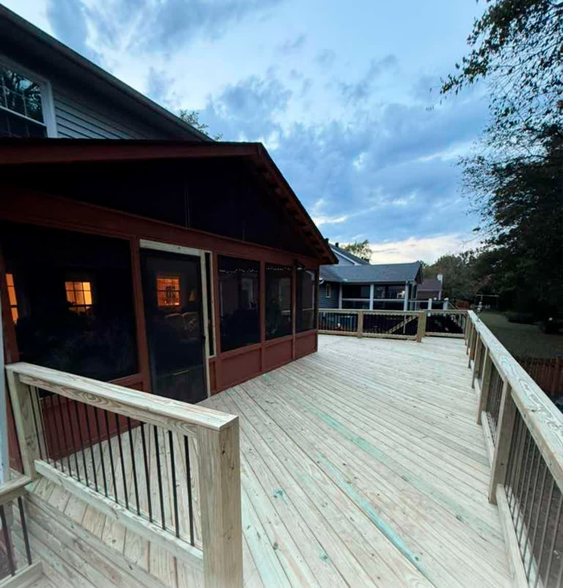Pressure-treated decking laid around a screened porch