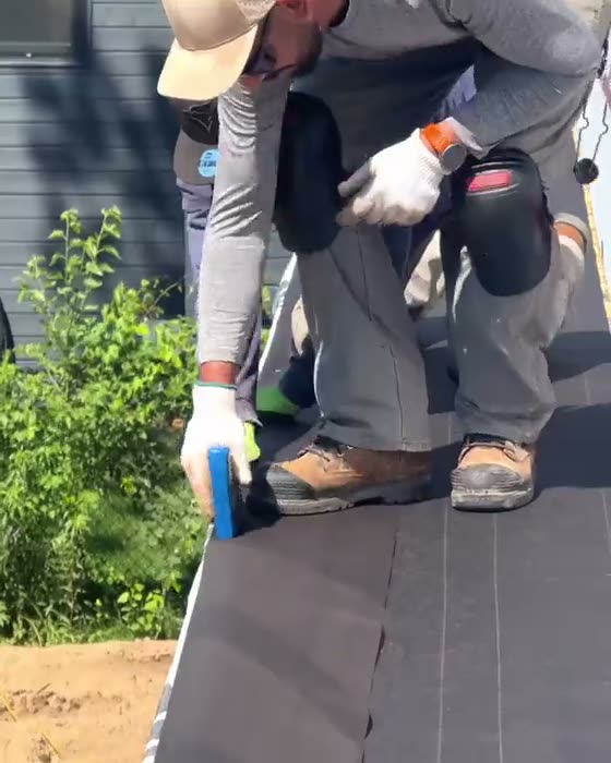 Architectural shingles being nailed to a roof deck